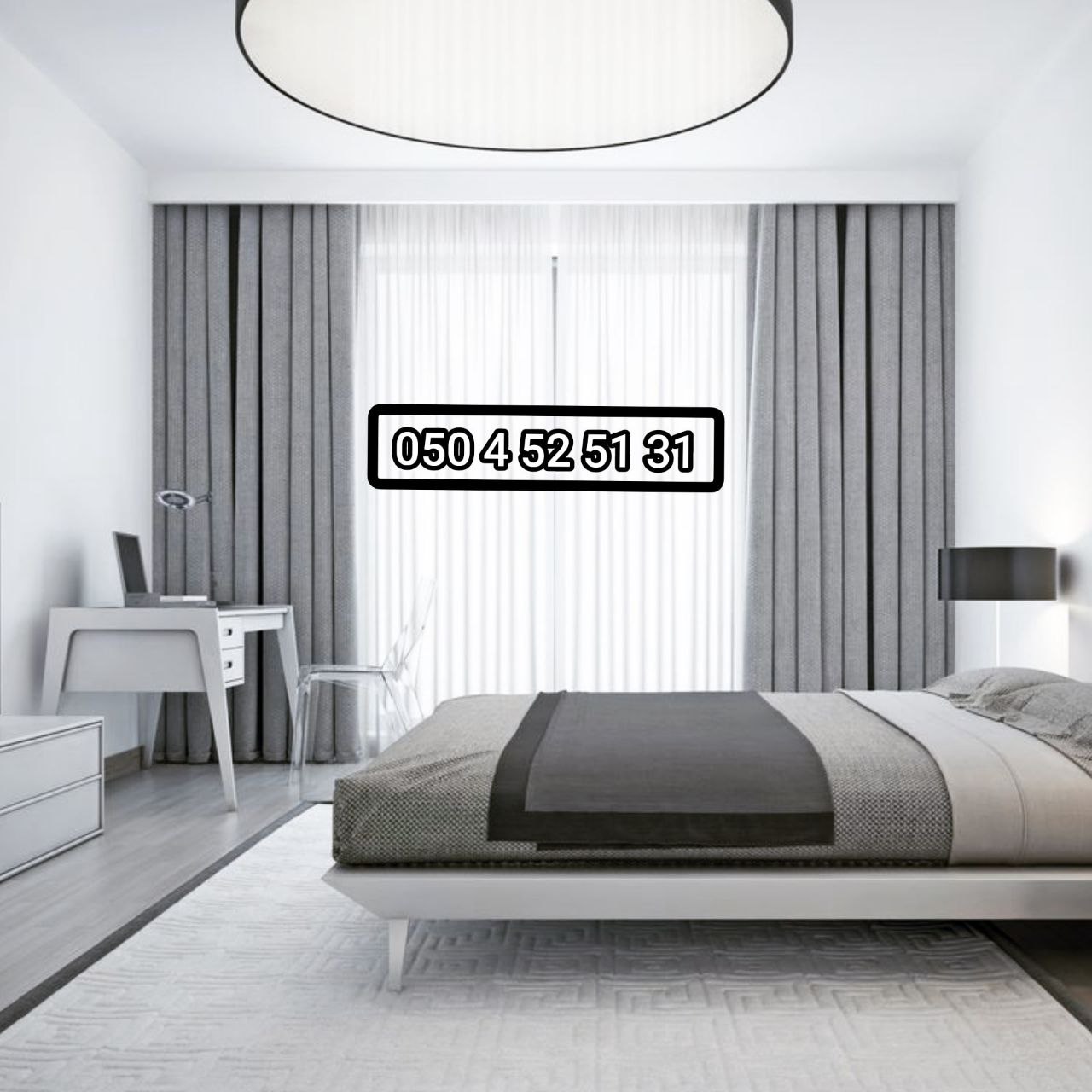 Grey blackout curtains with white sheers in a minimalist bedroom