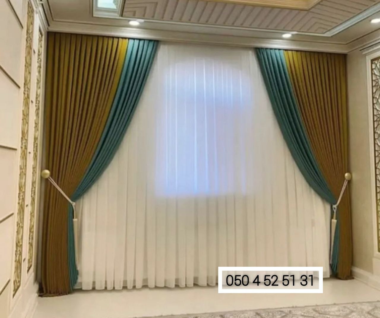 Gold and teal drapes with sheer curtains in a majlis